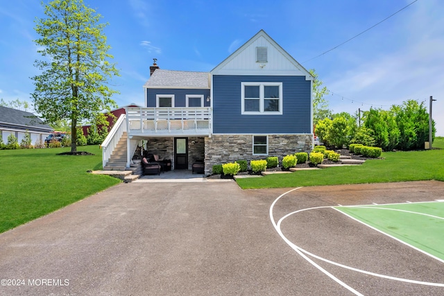 view of front of house with a front yard and basketball court