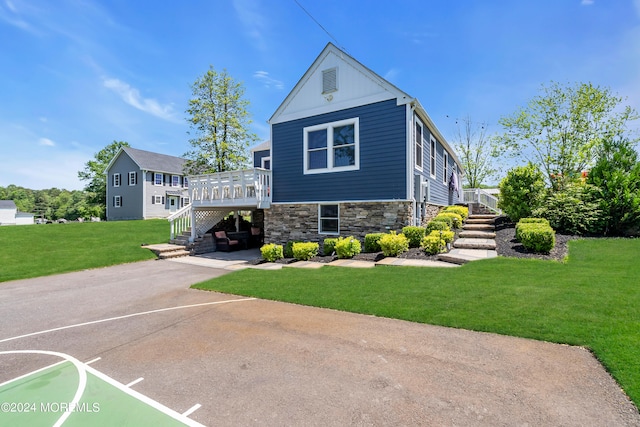 view of front of house with a wooden deck and a front lawn