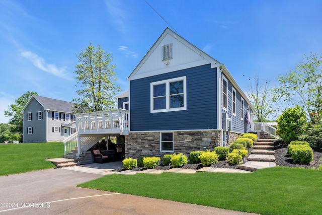 view of front of property featuring a front yard and a deck