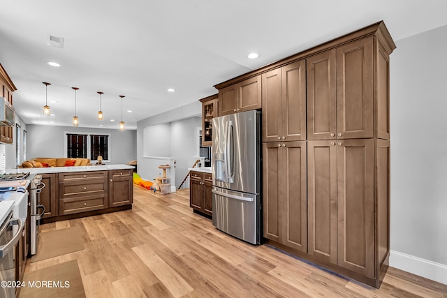 kitchen featuring light hardwood / wood-style flooring, stainless steel refrigerator with ice dispenser, and pendant lighting