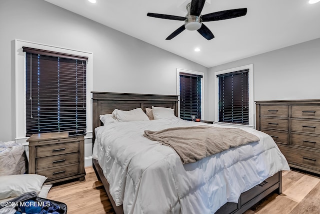 bedroom with ceiling fan, light wood-type flooring, and lofted ceiling