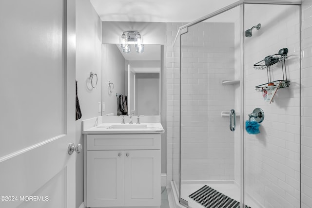 bathroom with vanity with extensive cabinet space and an enclosed shower