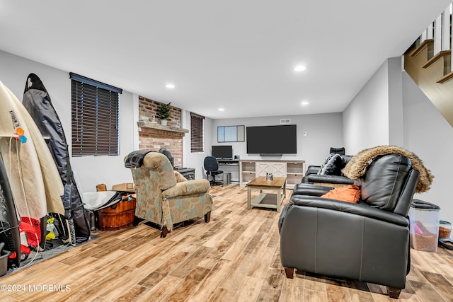 living room featuring light hardwood / wood-style flooring and brick wall