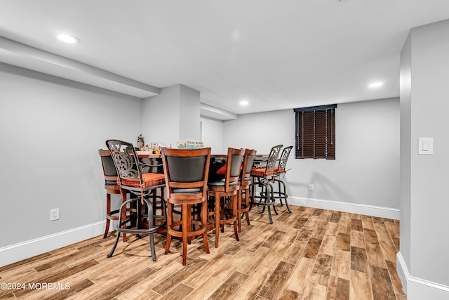 dining room with bar and light hardwood / wood-style flooring