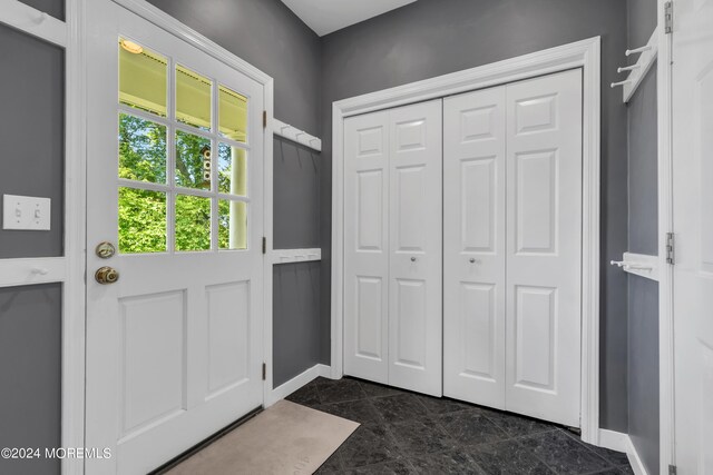 entryway with dark tile flooring