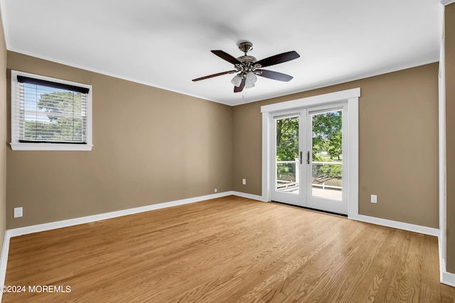 empty room with ceiling fan, french doors, and light wood-type flooring