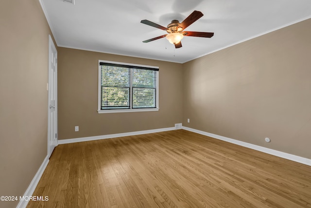 empty room featuring ceiling fan, light wood-type flooring, and ornamental molding