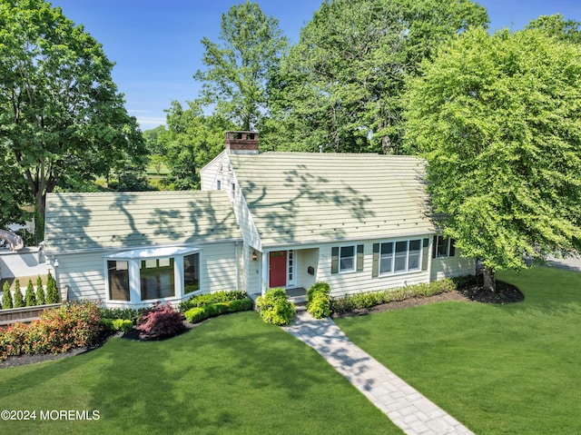 cape cod house featuring a front yard