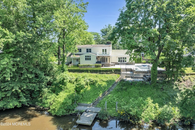 back of property with a deck with water view