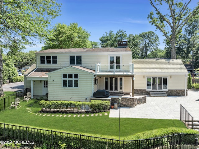 rear view of house featuring a patio and a lawn