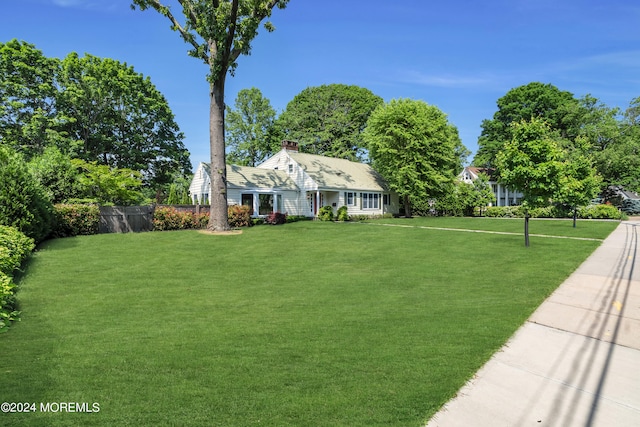 cape cod-style house featuring a front yard