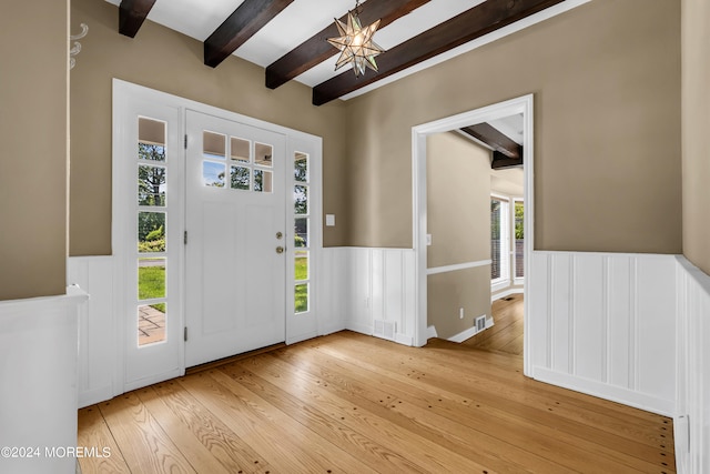 entrance foyer featuring plenty of natural light, beam ceiling, and light wood-type flooring