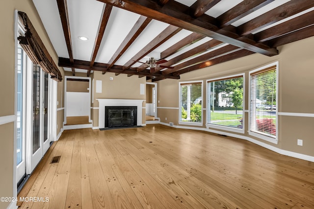 unfurnished living room with ceiling fan, beam ceiling, light hardwood / wood-style floors, and a fireplace