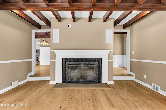 unfurnished living room featuring beam ceiling and hardwood / wood-style flooring