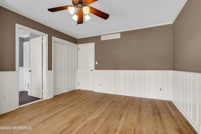 empty room featuring ceiling fan, light hardwood / wood-style floors, and crown molding