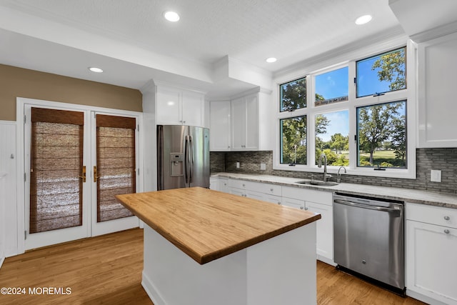 kitchen featuring appliances with stainless steel finishes, sink, a kitchen island, and light hardwood / wood-style flooring