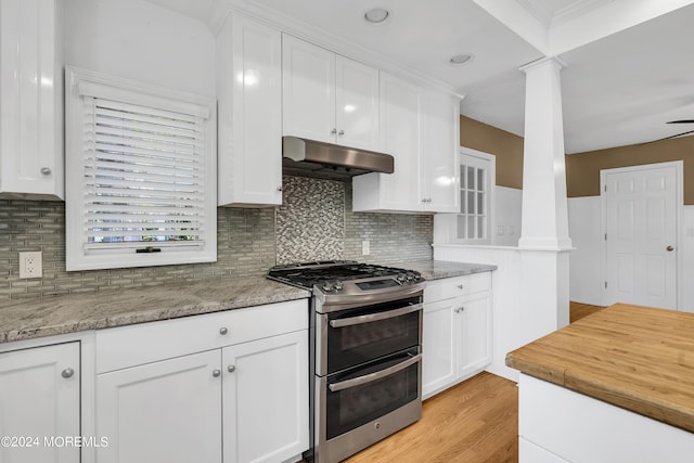 kitchen featuring ornate columns, double oven range, white cabinetry, and light hardwood / wood-style flooring