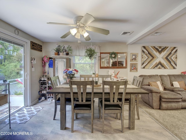 dining room featuring ceiling fan and concrete flooring