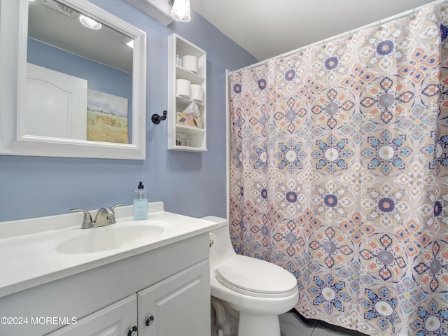 bathroom with tile flooring, toilet, and vanity