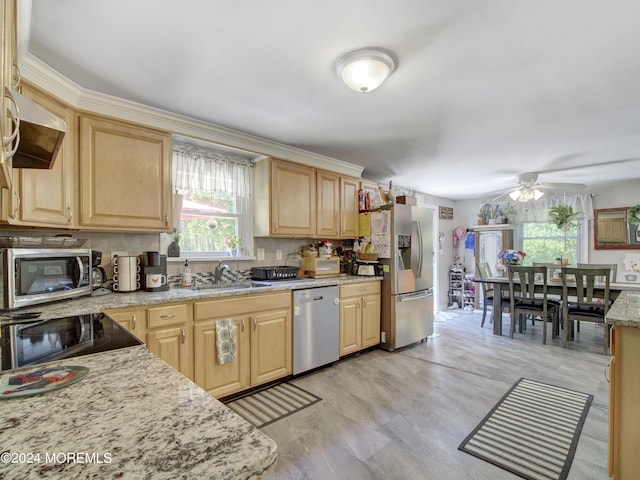 kitchen featuring light brown cabinets, ceiling fan, light hardwood / wood-style flooring, backsplash, and appliances with stainless steel finishes