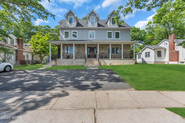 view of front of house featuring covered porch and a front lawn