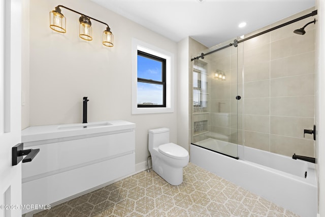 full bathroom with sink, toilet, and shower / bath combination with glass door