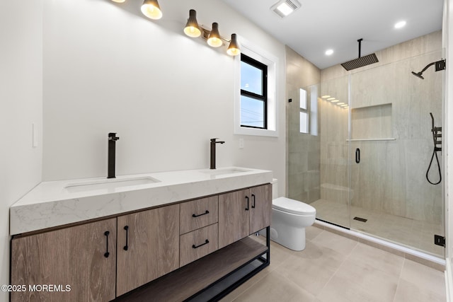 bathroom with toilet, tile patterned floors, vanity, and a shower with door