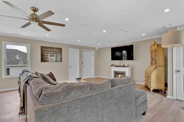 living room with crown molding, hardwood / wood-style floors, and ceiling fan