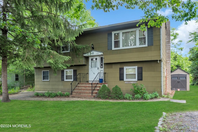 bi-level home with a front lawn and a storage shed