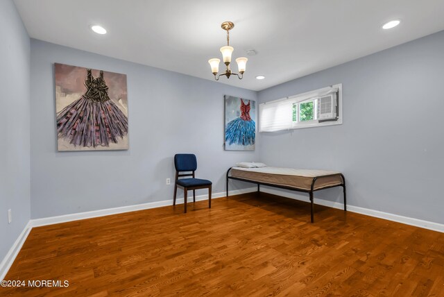 sitting room with wood-type flooring and an inviting chandelier