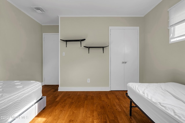 bedroom featuring hardwood / wood-style floors and ornamental molding