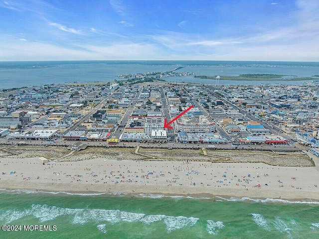 drone / aerial view with a water view and a beach view