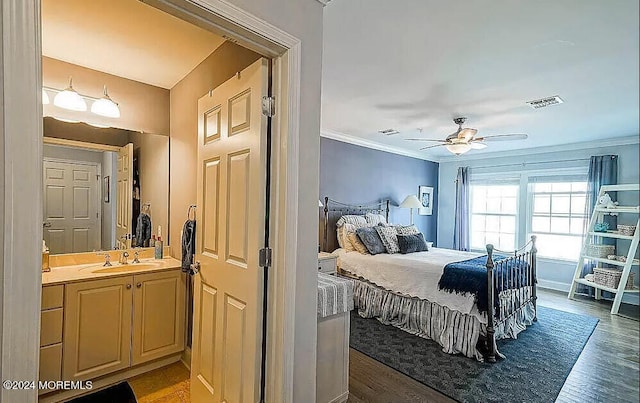 bedroom featuring ornamental molding, hardwood / wood-style floors, sink, and ceiling fan