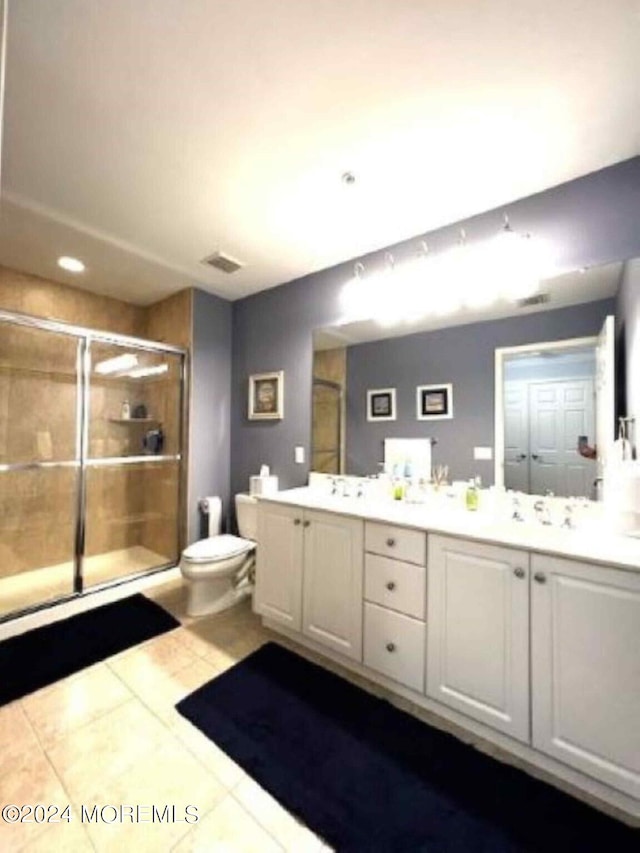 bathroom with walk in shower, tile patterned flooring, dual bowl vanity, and toilet