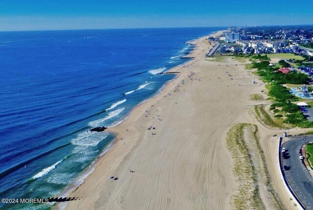 drone / aerial view featuring a beach view and a water view