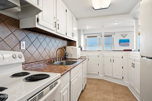 kitchen with backsplash, sink, light tile patterned floors, white appliances, and white cabinetry