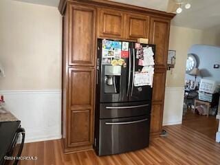 kitchen with black fridge, stove, and wood-type flooring