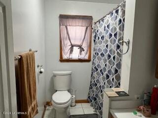 bathroom with tile patterned flooring, a shower with shower curtain, and toilet