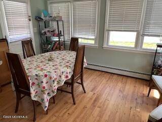 dining area with light hardwood / wood-style floors and a baseboard heating unit