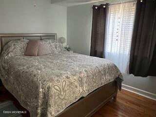 bedroom featuring multiple windows and dark wood-type flooring