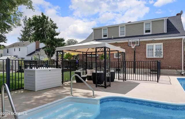 rear view of property featuring a gazebo, a patio area, and a fenced in pool