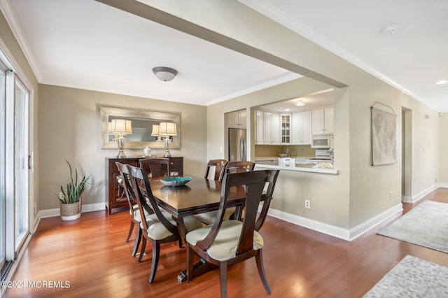 dining space featuring crown molding, plenty of natural light, and hardwood / wood-style flooring