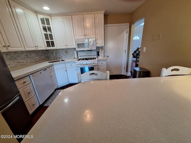 kitchen featuring white cabinetry, sink, and white appliances