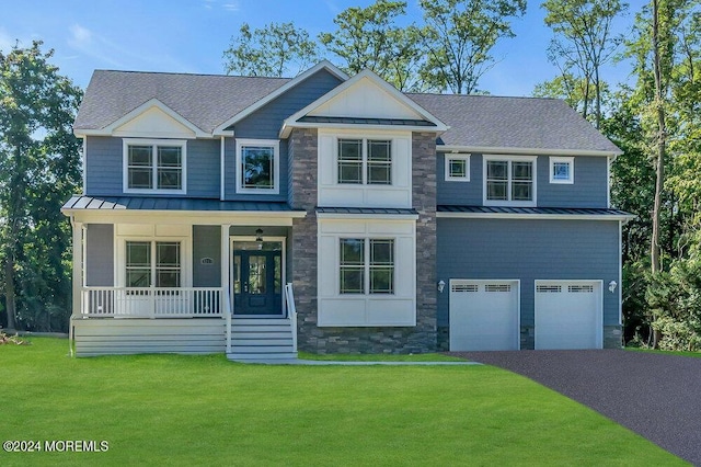 view of front of home with a garage, a front yard, and covered porch