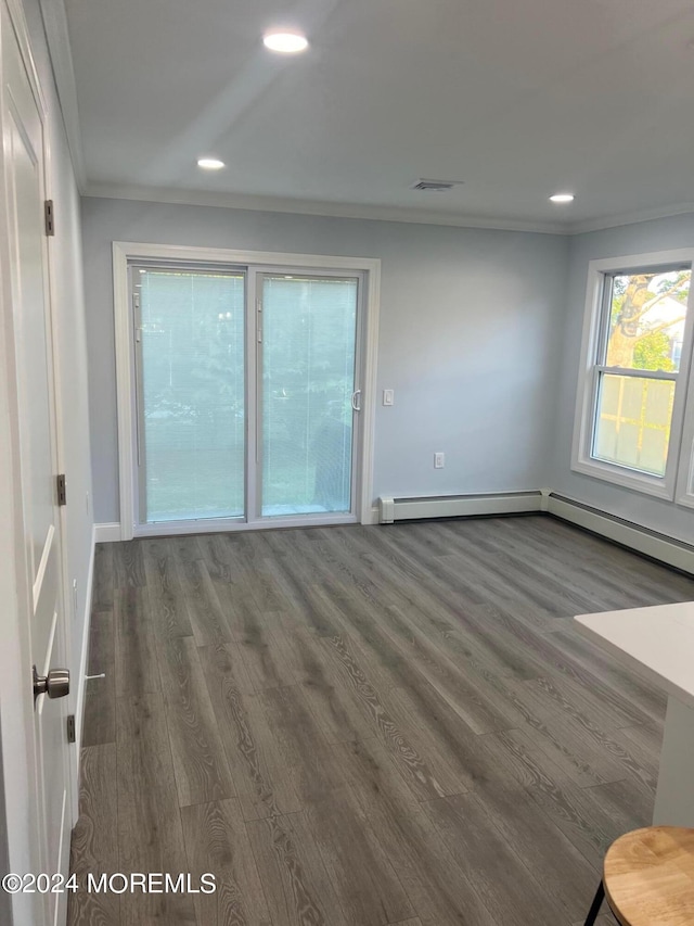 spare room with a baseboard heating unit, dark hardwood / wood-style floors, and ornamental molding