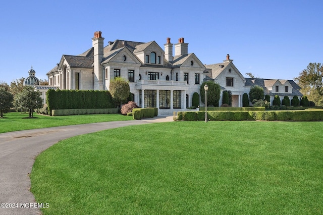 view of front of home featuring a front lawn and a balcony