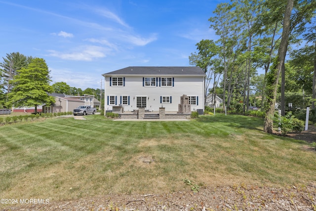 rear view of property featuring a lawn