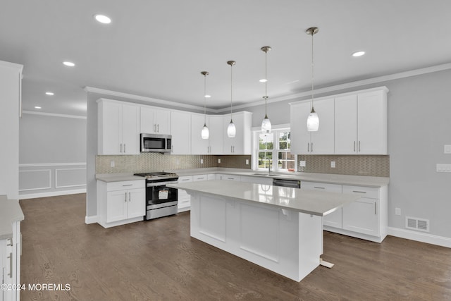 kitchen featuring a kitchen island, white cabinetry, hanging light fixtures, and appliances with stainless steel finishes