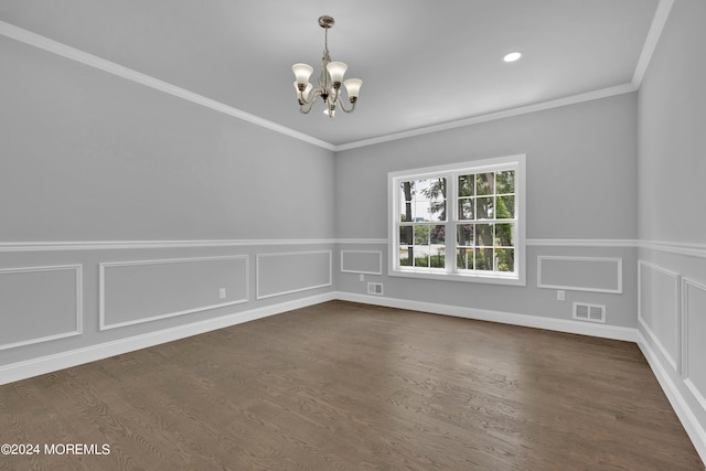 spare room with dark hardwood / wood-style flooring, an inviting chandelier, and ornamental molding