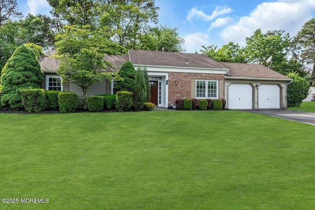 view of front facade featuring an attached garage, asphalt driveway, a front yard, and roof with shingles